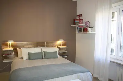 a bedroom with a bed with pillows and a window at Houses Donatello & Tiziano Roma in Rome