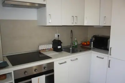 a kitchen with white cabinets and a sink at Houses Donatello & Tiziano Roma in Rome