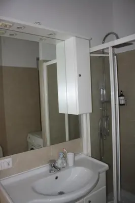 a bathroom with a sink and a shower and a mirror at Houses Donatello & Tiziano Roma in Rome