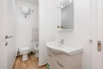 a white bathroom with a sink and a toilet at central comfortable studio apartment in Rome