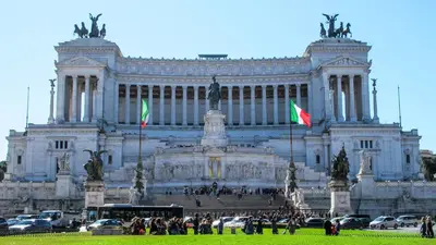 a large building with two flags in front of it at Colosseo Luxury Suite in Rome