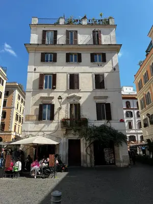 a tall building with people sitting in front of it at Colosseo Luxury Suite in Rome