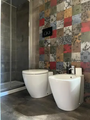 a bathroom with a white toilet and a sink at Colosseo Luxury Suite in Rome