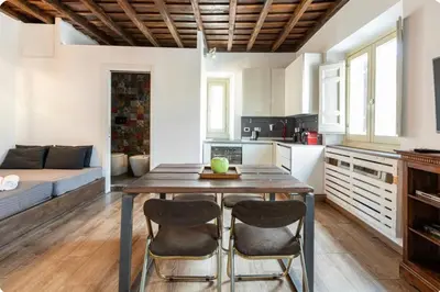 a kitchen and living room with a wooden table and chairs at Colosseo Luxury Suite in Rome