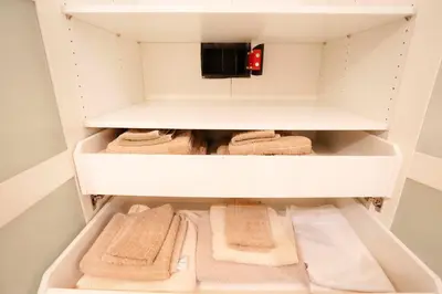 a small closet with white shelves and towels at Opera House in Rome