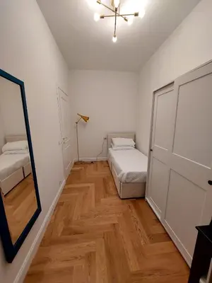 a small bedroom with two beds and a mirror at casa gemelli vaticano roma in Rome
