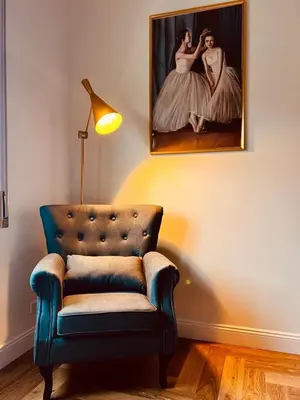 a living room with a chair and a painting on the wall at casa gemelli vaticano roma in Rome