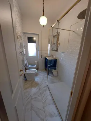a bathroom with two toilets and a shower and a sink at casa gemelli vaticano roma in Rome