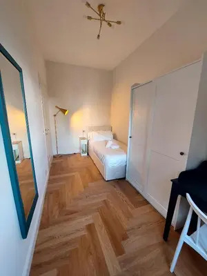 a bedroom with a white bed and a wooden floor at casa gemelli vaticano roma in Rome