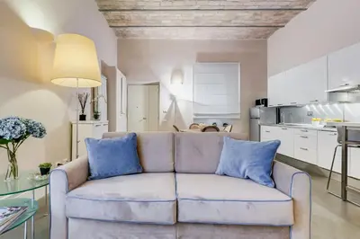 a living room with a couch and a kitchen at New Suite Barberini Area in Rome
