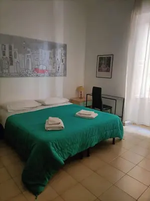 a bedroom with a green bed with two towels on it at Appartamento di Mila in Rome
