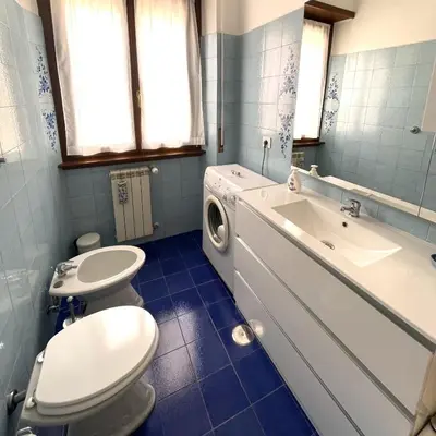 a bathroom with two toilets and a sink and a washing machine at Lazy Time Apartment in Rome