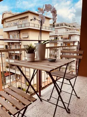 a table and chairs on a balcony with a building at Lazy Time Apartment in Rome