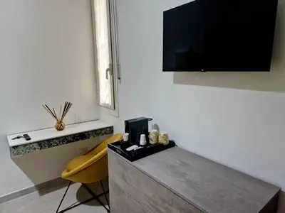 a living room with a tv and a yellow chair at Tiburtina Keys - Roma in Rome