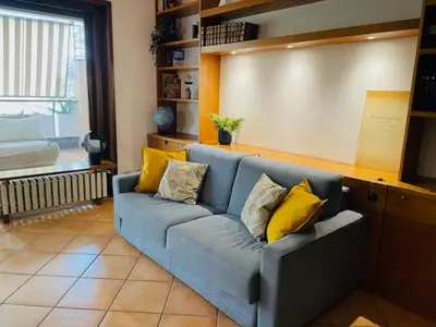 a living room with a blue couch with yellow pillows at Da Cecilia alla Piramide Cestia in Rome