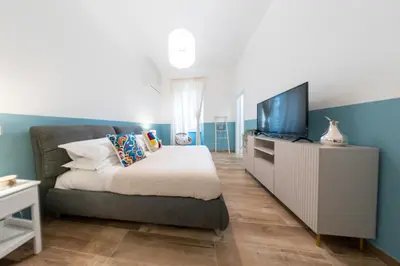 a bedroom with a bed and a flat screen tv at Colosseo Home San Giovanni in Rome