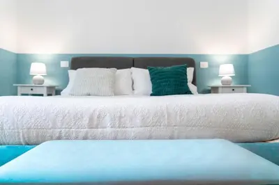 a bedroom with a large bed with blue walls at Colosseo Home San Giovanni in Rome