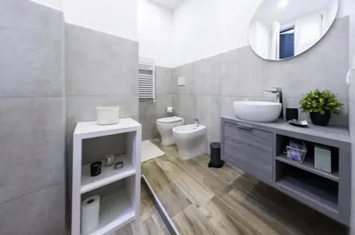 a bathroom with a sink and a toilet and a mirror at Colosseo Home San Giovanni in Rome
