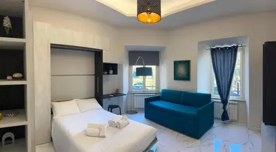 a bedroom with a bed and a blue couch at Dielle Suite ROMA in Rome