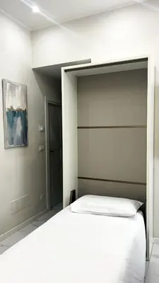 a bedroom with a large white bed with a headboard at Dielle Suite ROMA in Rome