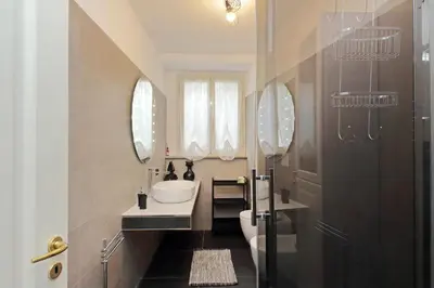 a bathroom with a sink and a toilet and mirrors at 4BNB - Ponte Milvio Apartment in Rome