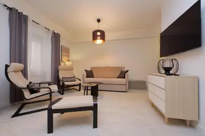 a living room with a couch and chairs and a tv at 4BNB - Ponte Milvio Apartment in Rome