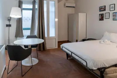 a bedroom with a bed and a table and chairs at Studio Flat - Lungara 44A in Rome