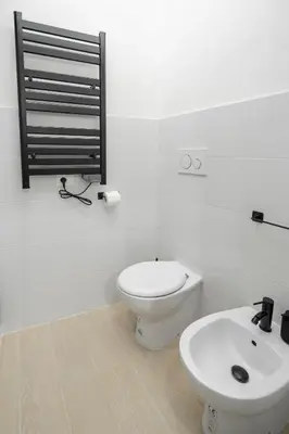 a white bathroom with a toilet and a sink at Studio Flat - Lungara 44A in Rome