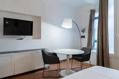 a living room with a table and chairs and a tv at Studio Flat - Lungara 44A in Rome