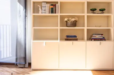 a white book shelf in a room with books at Amazing Elegant Jewish Ghetto in Rome