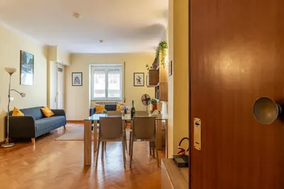 a living room with a table and a blue couch at San Paolo Apartment - Charme Holidays in Rome