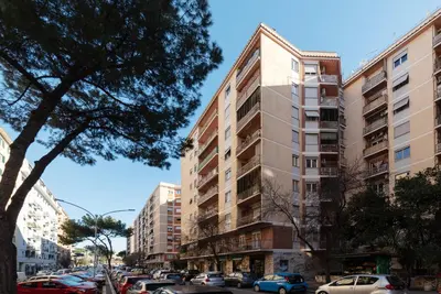 a street with cars parked in front of tall buildings at San Paolo Apartment - Charme Holidays in Rome