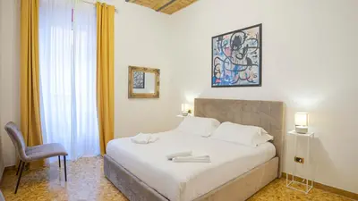 a bedroom with a bed and a chair in a room at Candia Delizioso Appartamento vicino al Vaticano in Rome