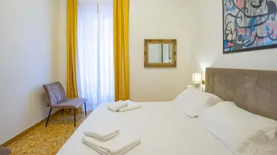 a bedroom with a bed and a chair and a mirror at Candia Delizioso Appartamento vicino al Vaticano in Rome