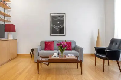 a living room with a couch and a table with flowers at Beige luxury apartment Rome in Rome