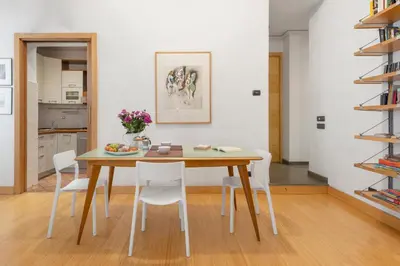 a dining room with a wooden table and white chairs at Beige luxury apartment Rome in Rome