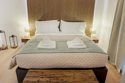 a bedroom with a large bed with two towels on it at Minerva Boutique Residence in Rome