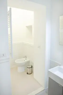 a white bathroom with a toilet and a sink at Minerva Boutique Residence in Rome