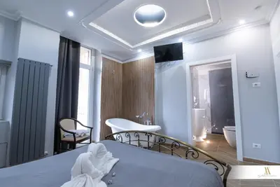 a bedroom with a large bed and a mirror at Angelus Vaticanus Room in Rome