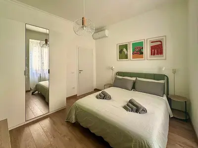 a bedroom with a large bed and a mirror at MuMo Home Pigneto in Rome
