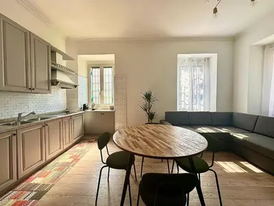 a kitchen and living room with a table and a couch at MuMo Home Pigneto in Rome