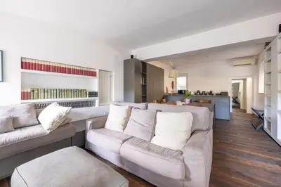 a living room with two white couches and a kitchen at Farnesi Terrace Penthouse in Rome