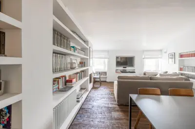 a living room with a couch and bookshelves at Farnesi Terrace Penthouse in Rome