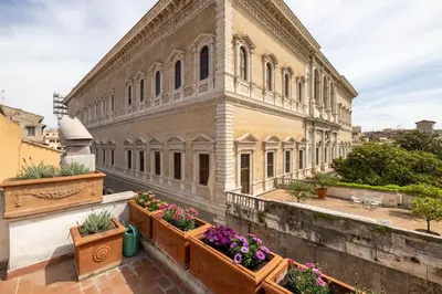 an old building with potted plants on a balcony at Farnesi Terrace Penthouse in Rome