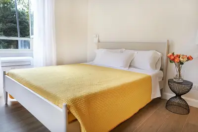 a bedroom with a bed with a yellow bedspread at Reyes Suite & Rooms in Rome