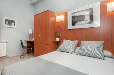 a bedroom with a bed with two pillows on it at Reyes Suite & Rooms in Rome