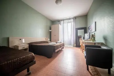 a bedroom with a bed and a desk and a sink at Reyes Suite & Rooms in Rome
