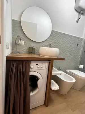 a bathroom with a washing machine and a sink at flaTminio modern & nice apartment in Rome