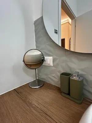 a bathroom with a mirror and a chair and a trash can at flaTminio modern & nice apartment in Rome