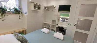 a small bedroom with a blue bed and a window at The Golden Pyramid in Rome